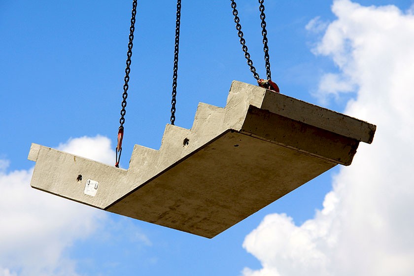 Bauteil einer Treppe hängt am Kran in der Luft