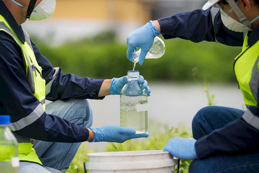 Zwei Menschen analysieren Wasser aus einer offenen Wasserhaltung